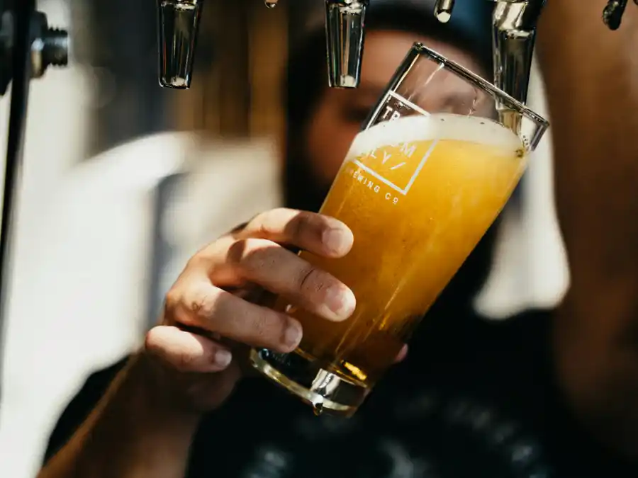Una birra chiara versata nel bicchiere direttamente dalla spina